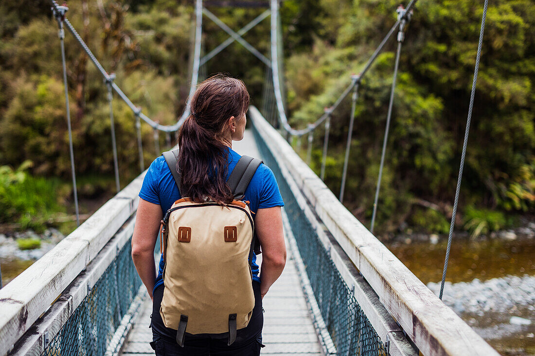 Woman walking through hanging bridge