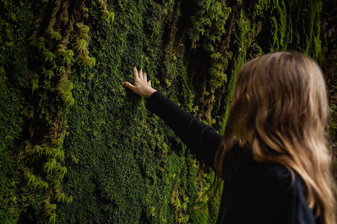 Girl touching moss