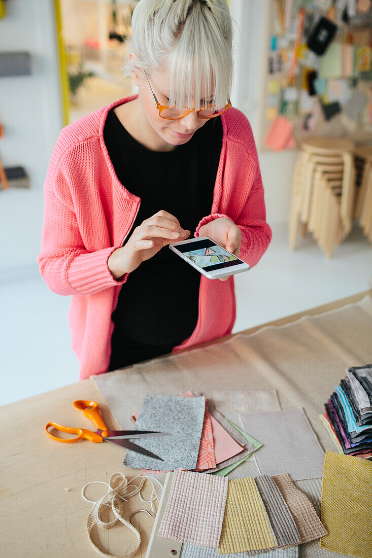 Woman taking photo of textiles in shop