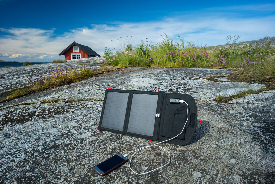Smartphone wird mit Solarladegerät aufgeladen