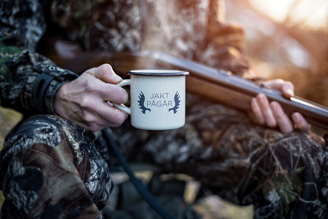 Jäger hält Becher