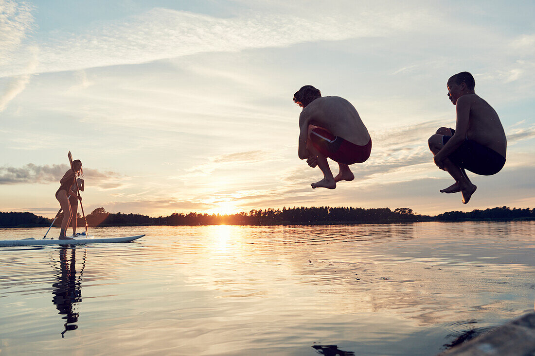 Boys jumping into lake