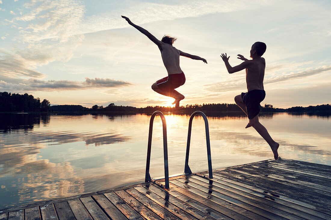 Boys jumping into lake