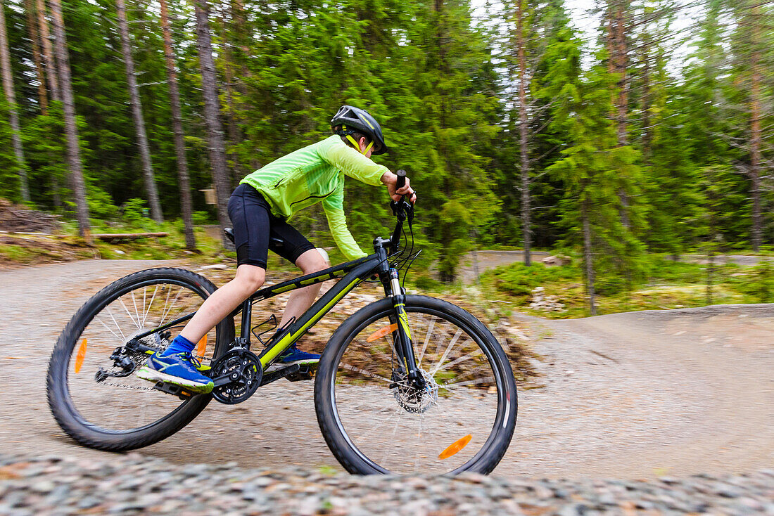 Boy cycling though forest