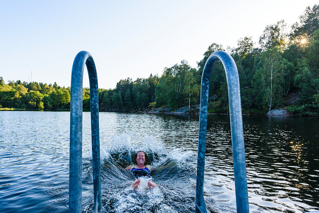 Glückliche Frau schwimmt im See