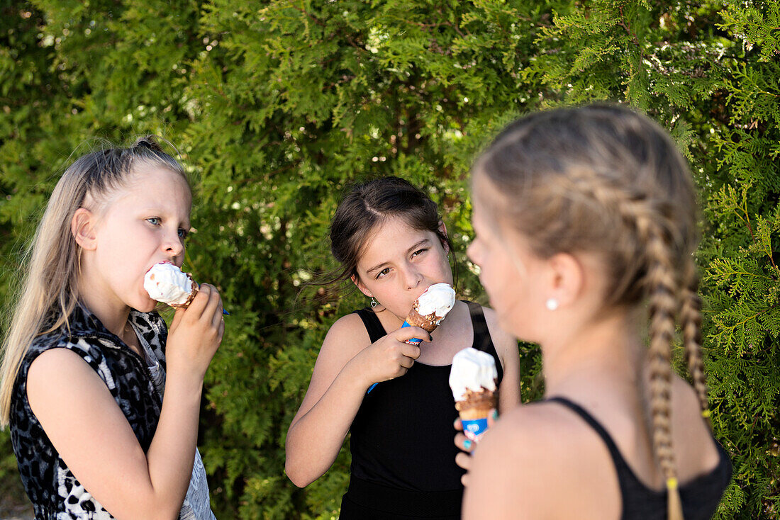 Drei Mädchen essen ein Eis.