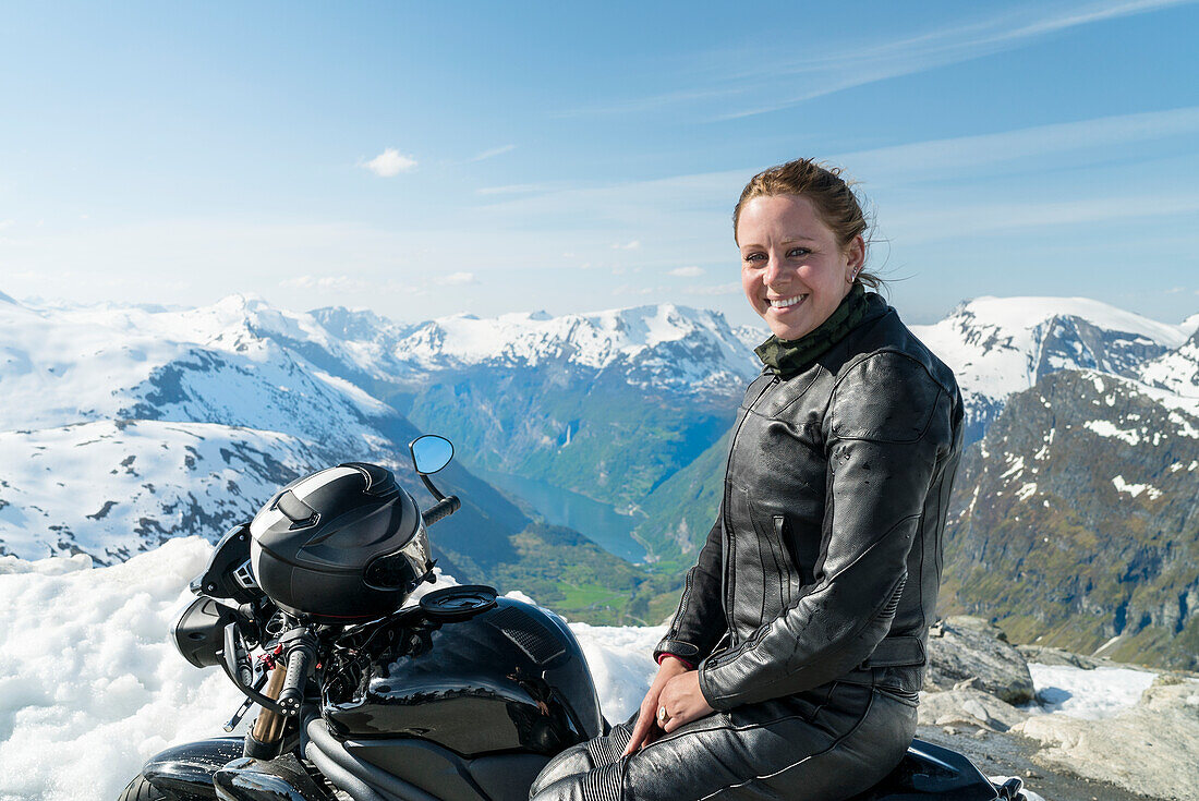 Porträt einer Frau auf einem Motorrad, Berge im Hintergrund