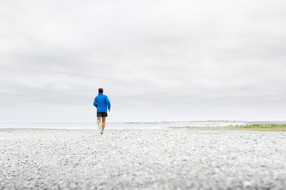 Mann joggt am Strand