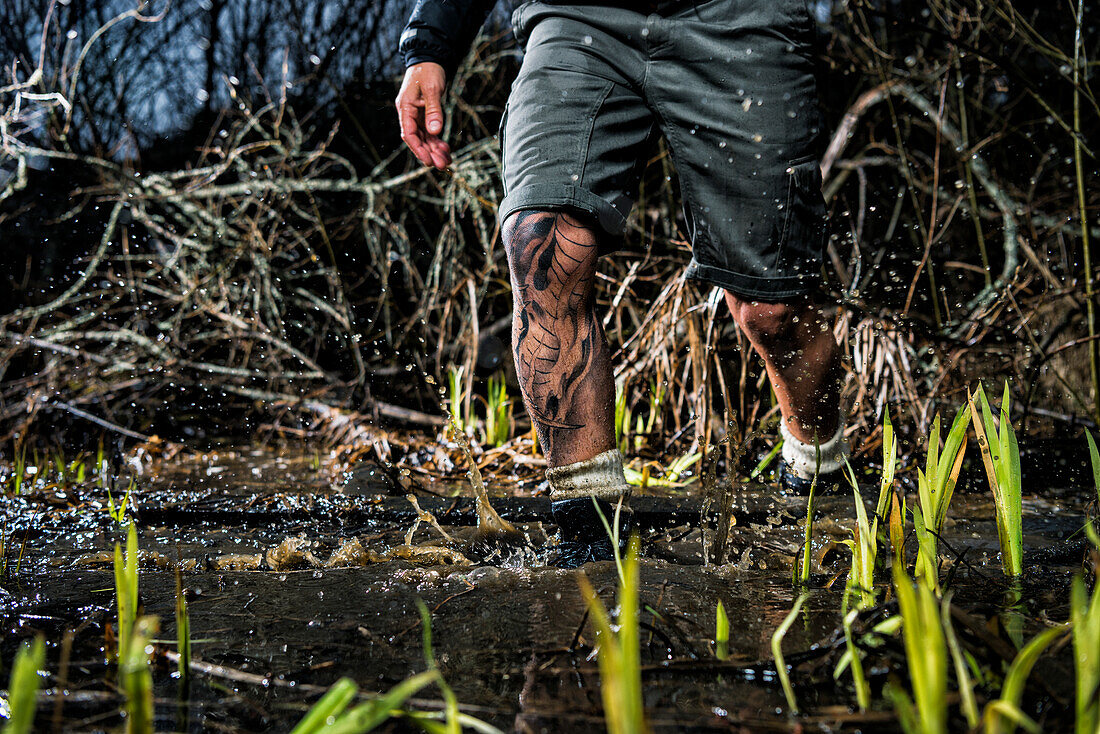 Man walking through swamp, low section