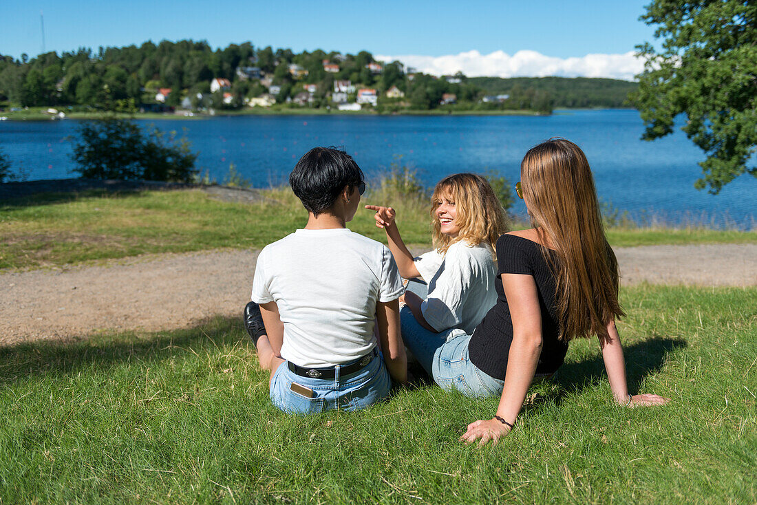 Female friends sitting at water