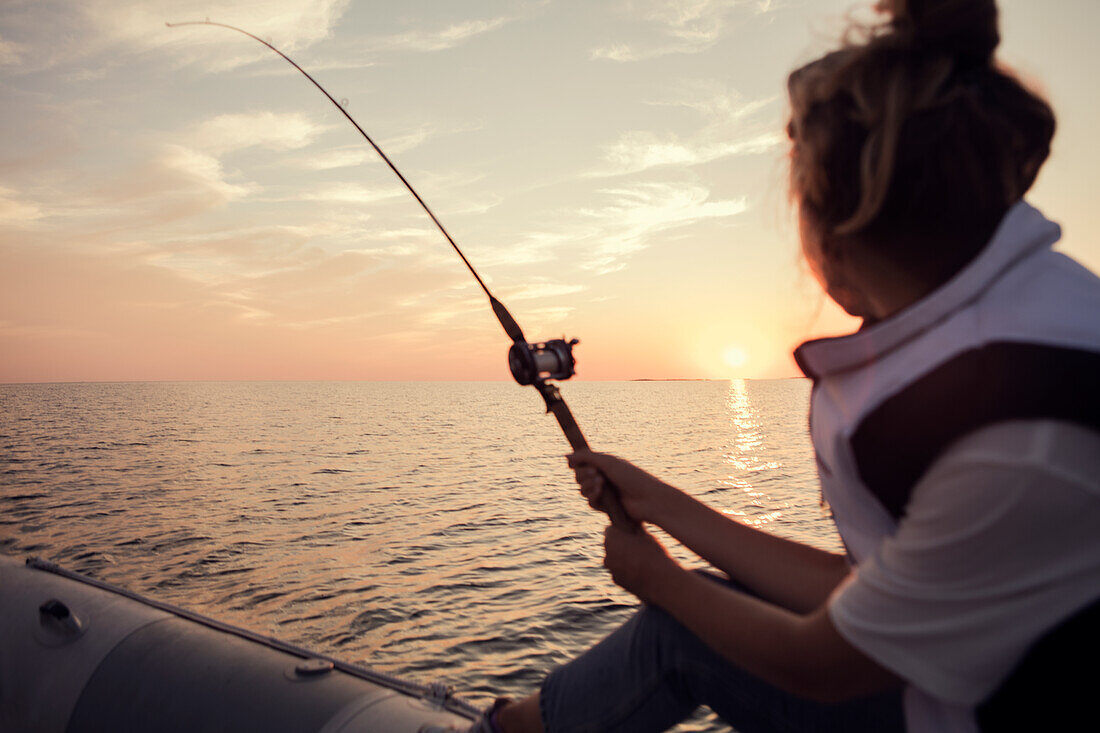 Woman fishing at sunset