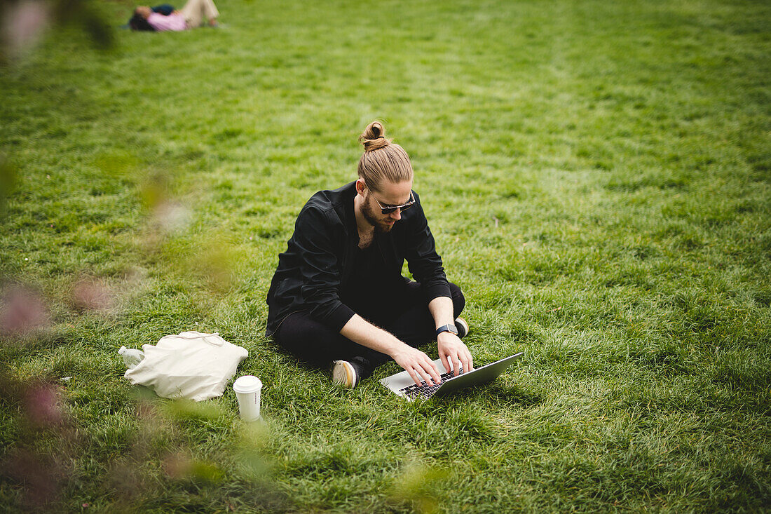 Man using laptop in park