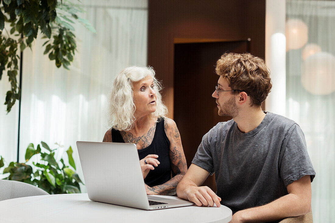 Man and woman working on laptop