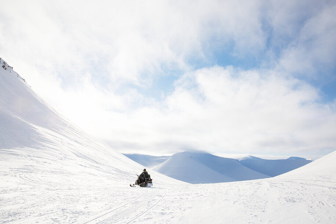 Mann auf Schneemobil in Winterlandschaft