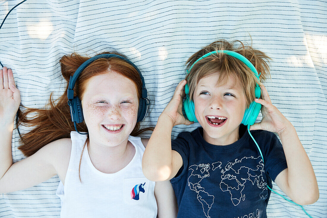Sibblings listening to music in headphones