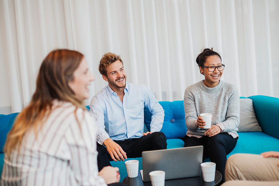 Four friends sitting in living room with laptop