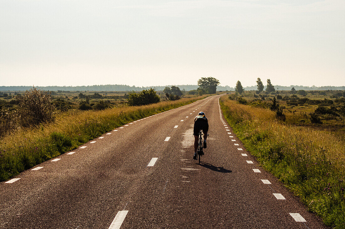 Person, die auf einer Landstraße Fahrrad fährt