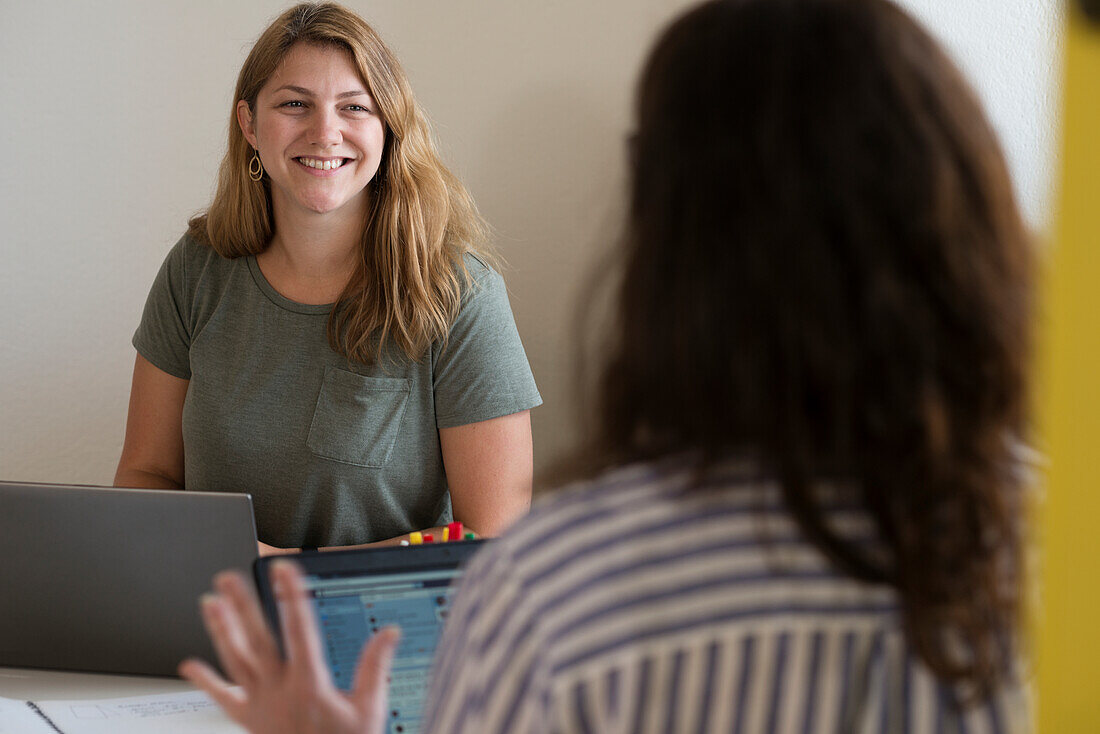 Smiling women talking in office