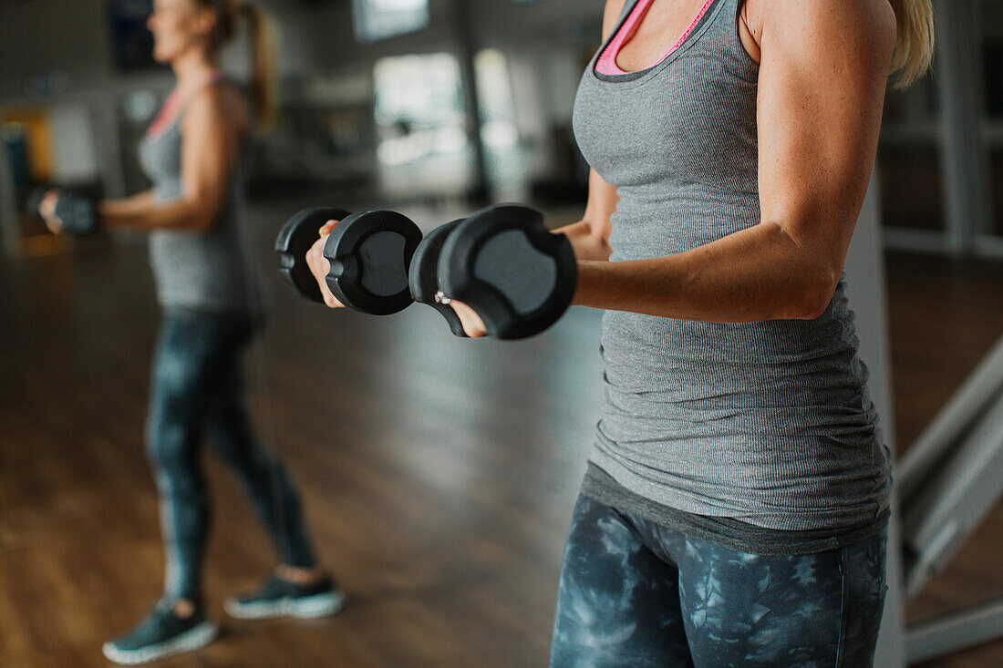Woman exercising with dumbbells in gym