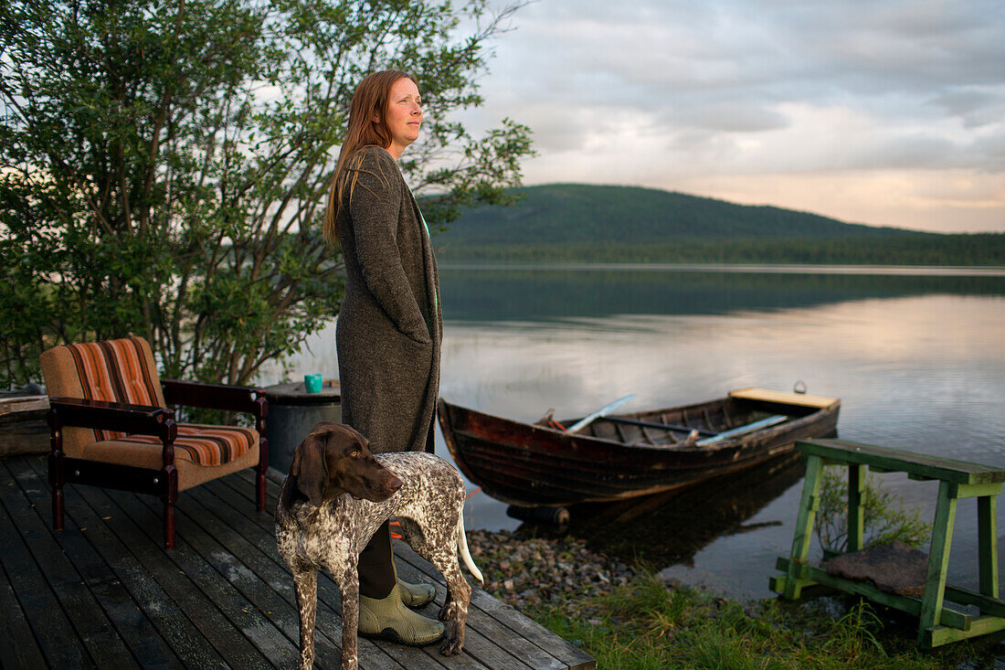 Frau mit Hund nachdenklich am Meer