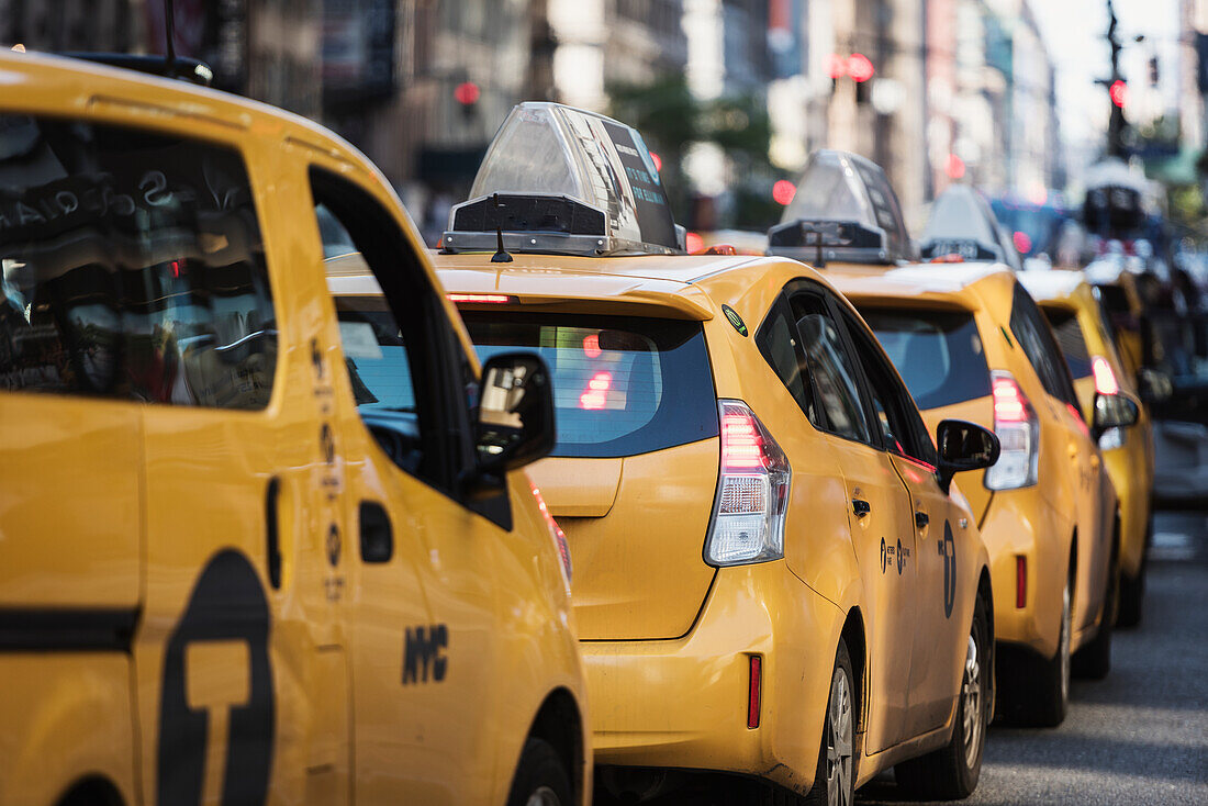 Reihe gelber Taxis auf einer Stadtstraße