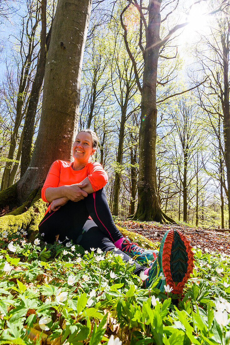 Lächelnde Frau ruht sich im Wald aus