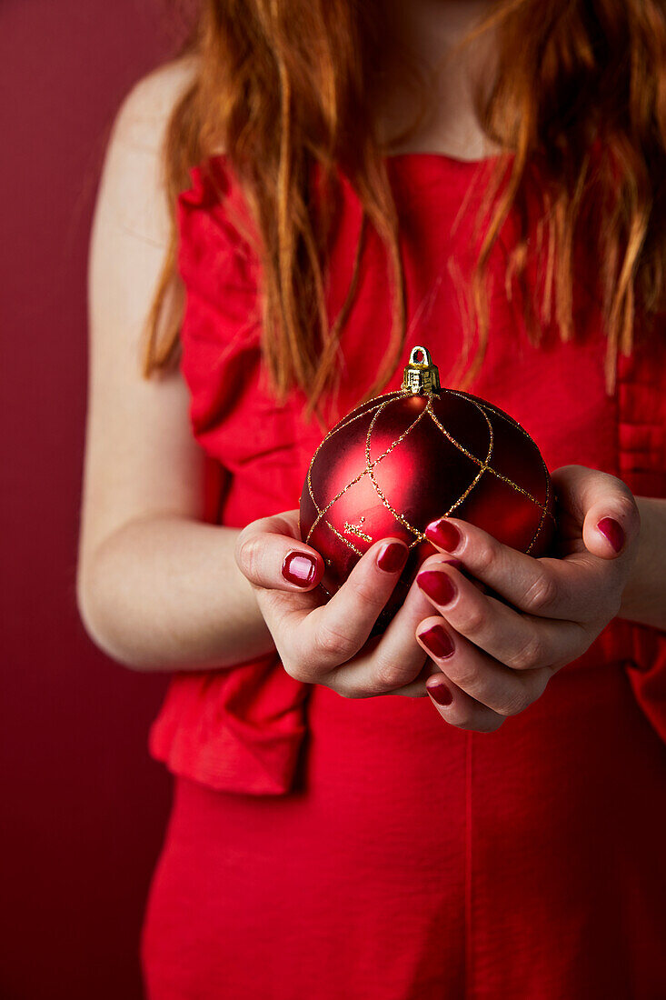 Child holding Christmas bauble, close-up
