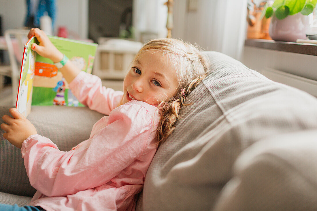 Girl on sofa with book