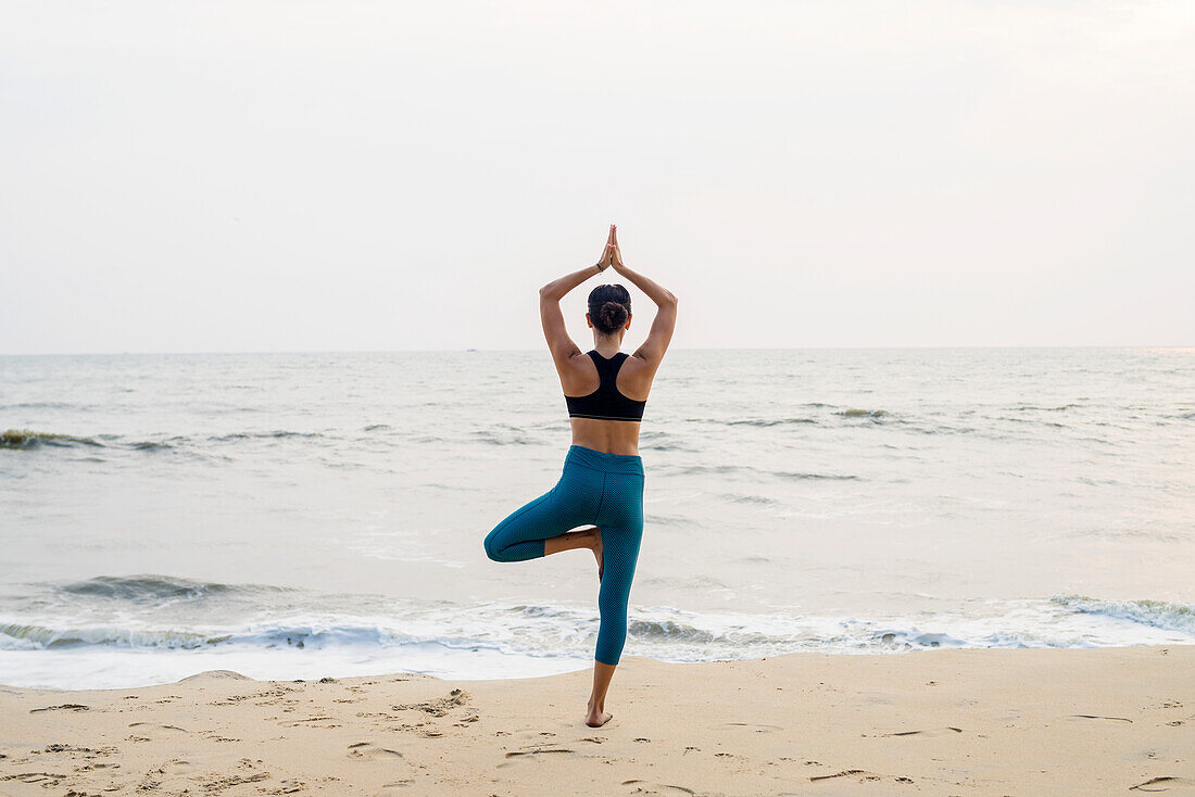 Frau am Strand beim Yoga