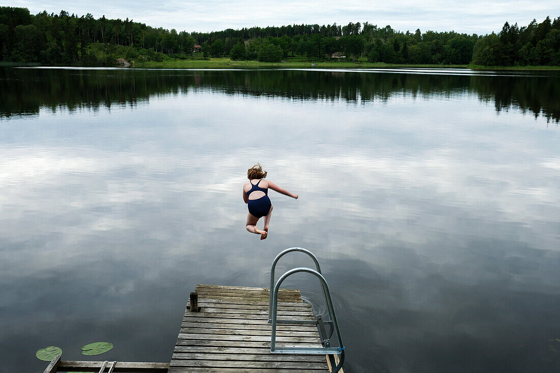 Girl jumping into lake