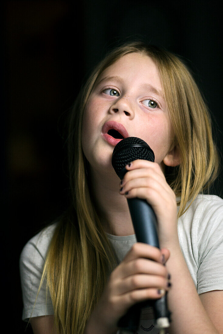 Girl holding microphone and singing