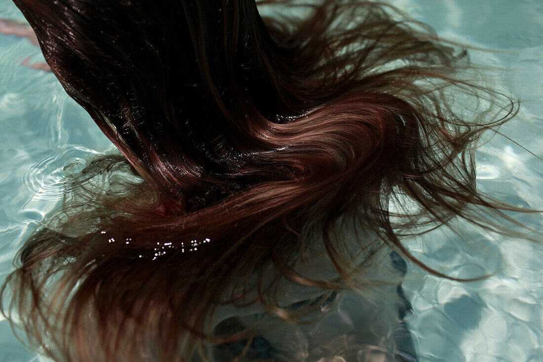 Braune Haare schwimmen auf der Wasseroberfläche