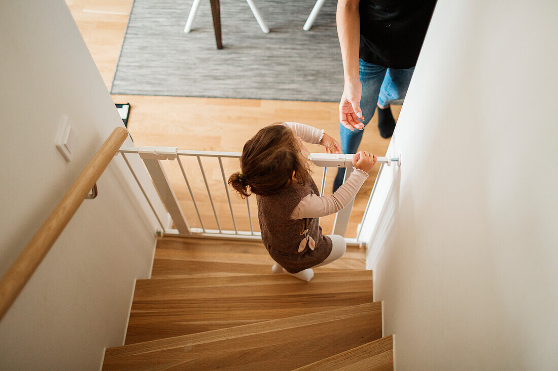 Mädchen öffnet Babyklappe im Treppenhaus