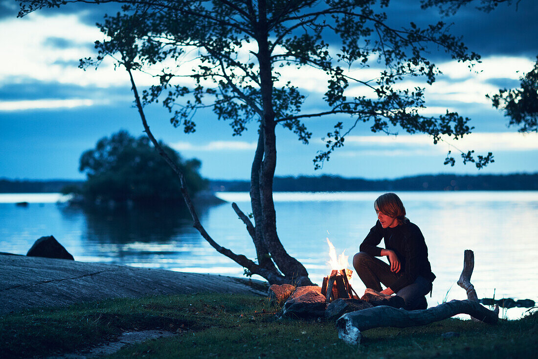 Man by campfire at dusk