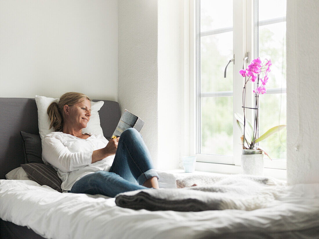 Woman reading book in bed