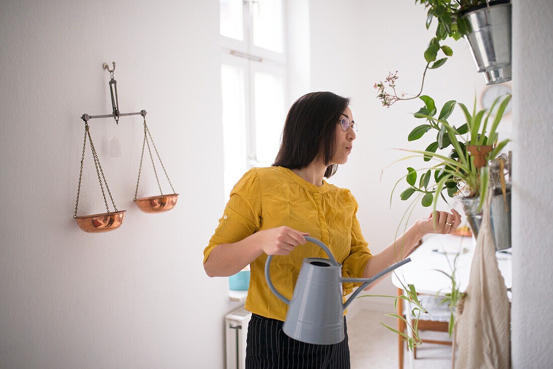 Frau bewässert Blumen