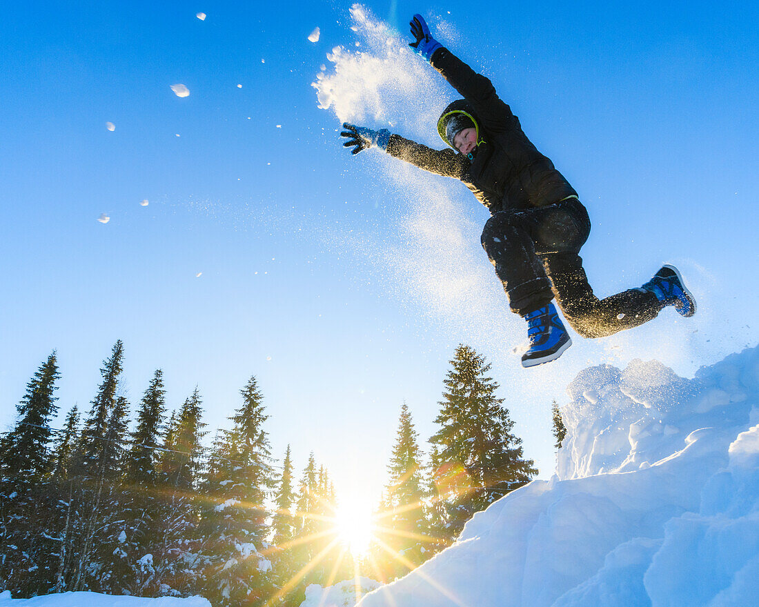 Junge, der in den Schnee springt