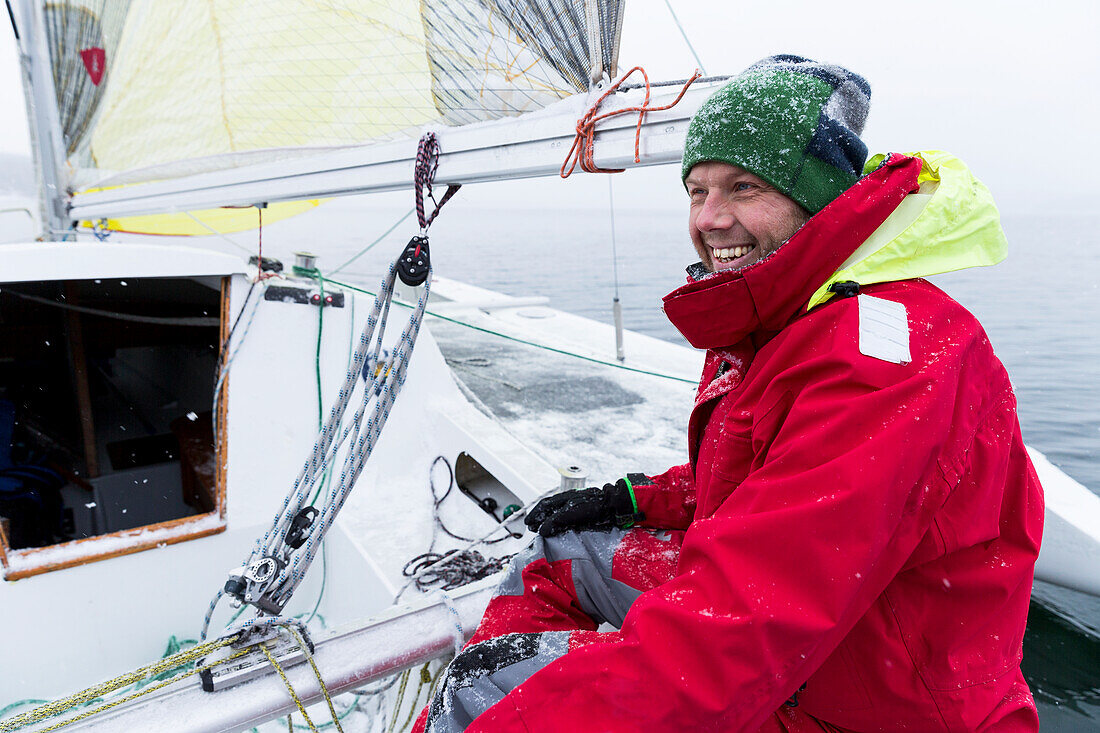 Smiling man on yacht on snowy day