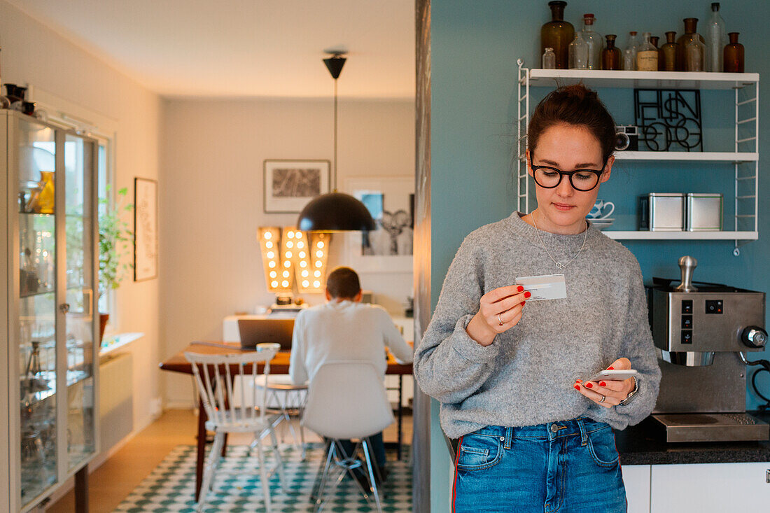 Woman using phone in kitchen