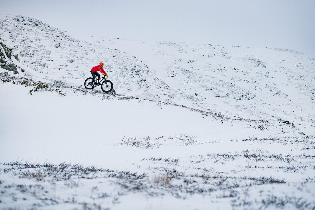 Man cycling in snow