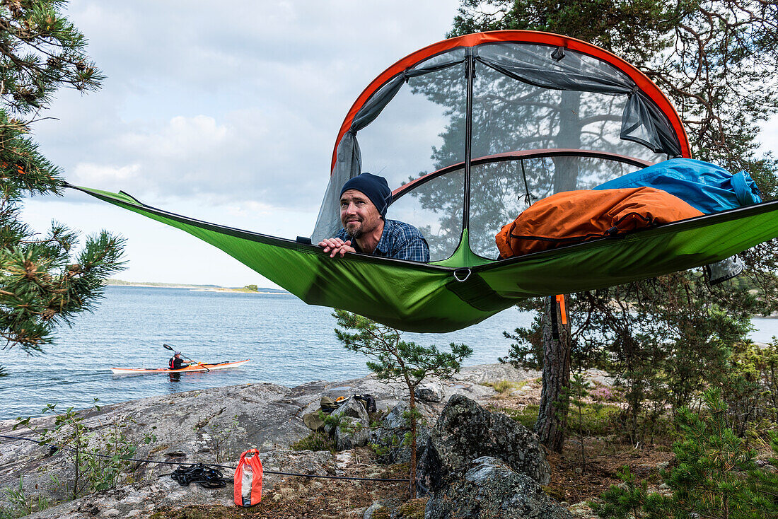 Man resting in hammock at lakeshore