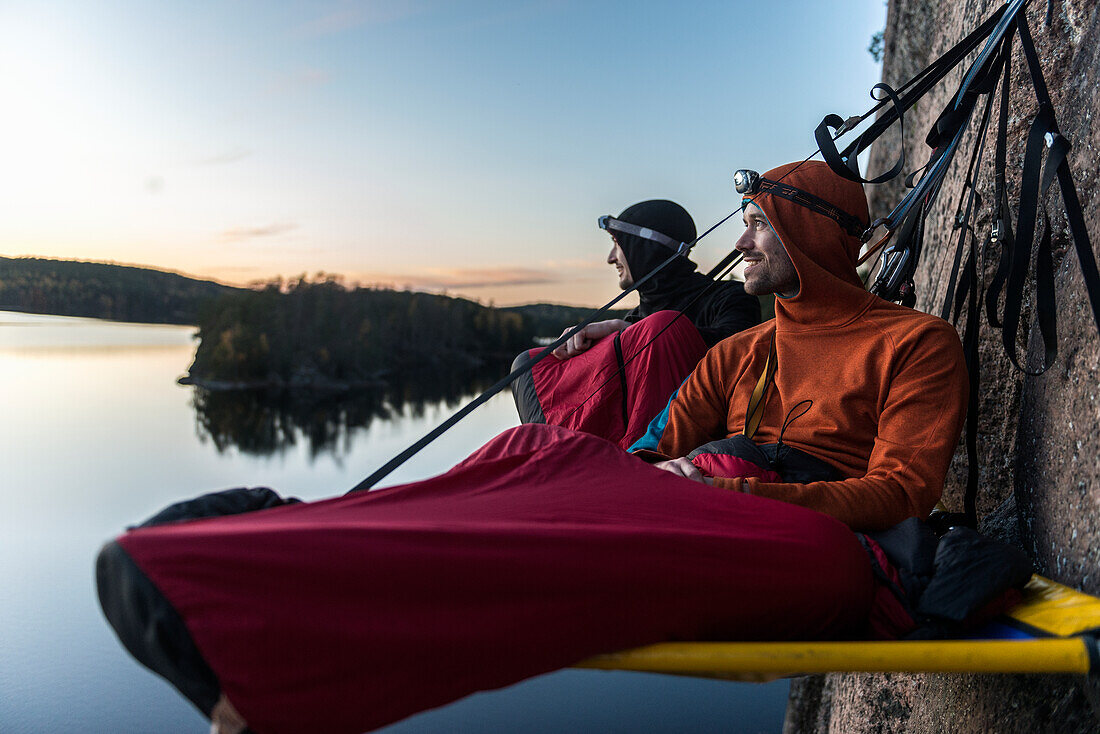 Zwei Wanderer ruhen sich in einer Portaledge aus