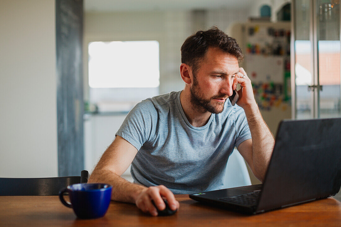 Mann benutzt Laptop zu Hause