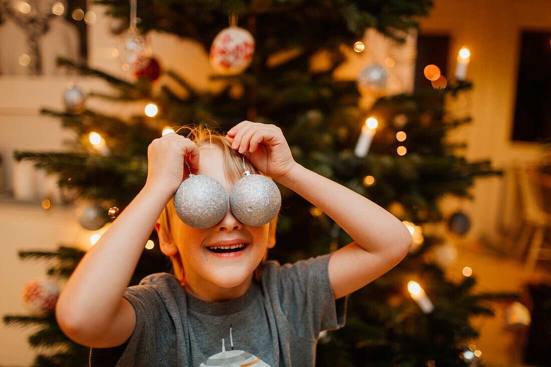 Boy playing with Christmas ornaments