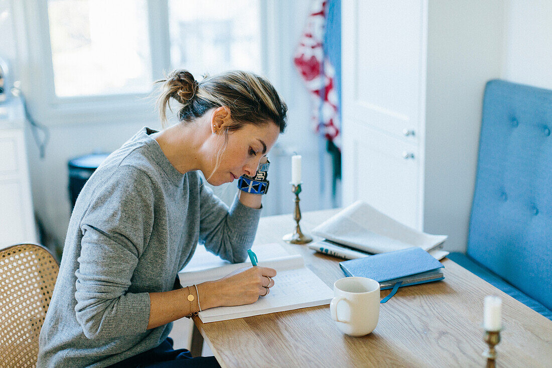 Junge Frau schreibt in ein Notizbuch