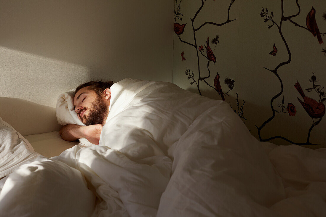 Mann schläft im Bett