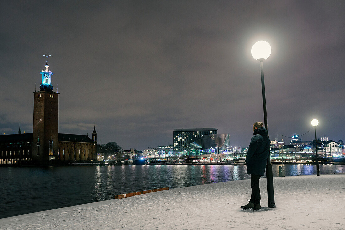 Mann mit Blick auf das Rathaus von Stockholm, Stockholm, Schweden