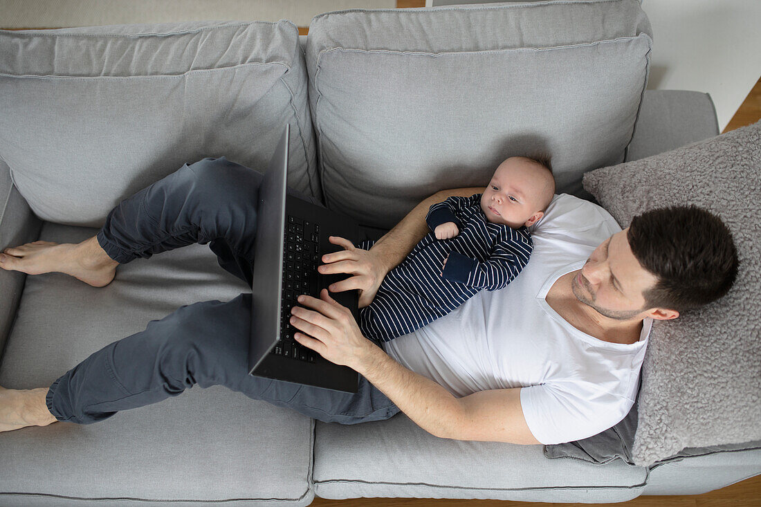 Mann mit Baby auf dem Sofa