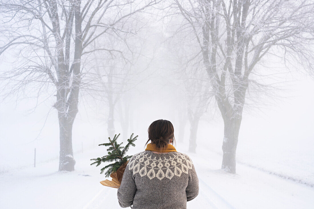 Woman with potted pine tree