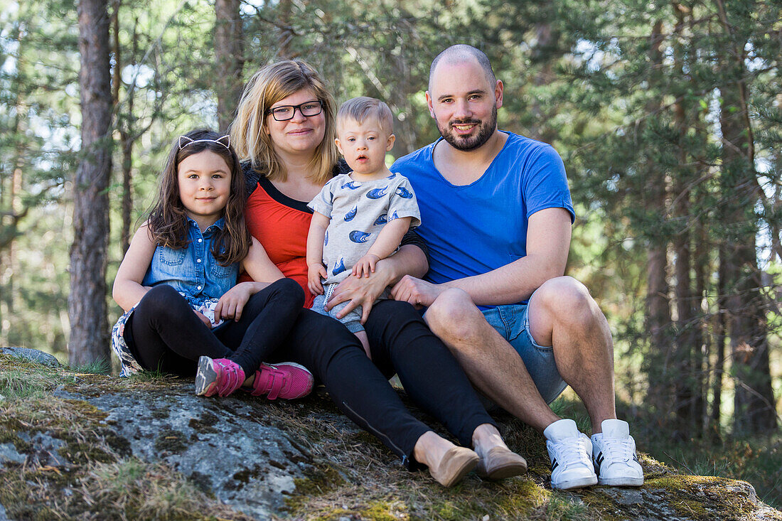 Vierköpfige Familie schaut in die Kamera